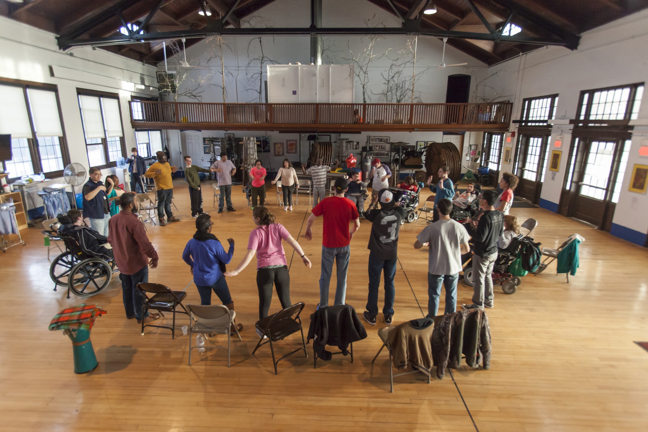 Group of young adults with various disabilities standing in a circle in a gym