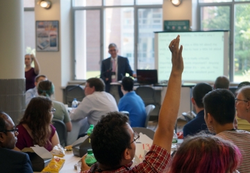 Young man raising his hand during a presentation