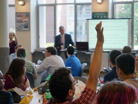 Young man raising his hand during a presentation