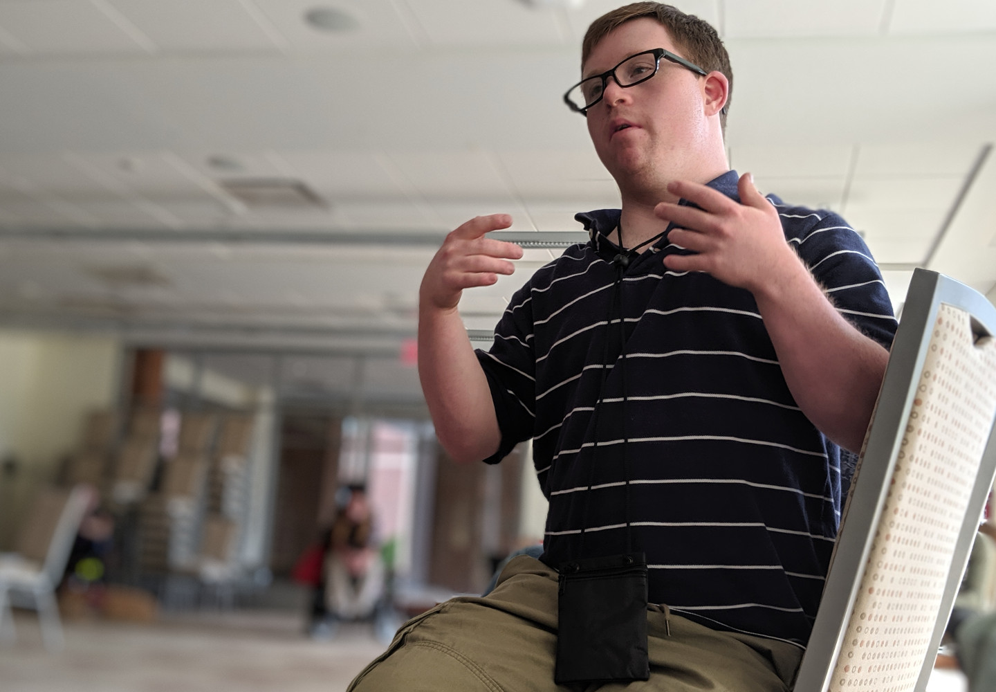 Young white student gesticulates while speaking in class