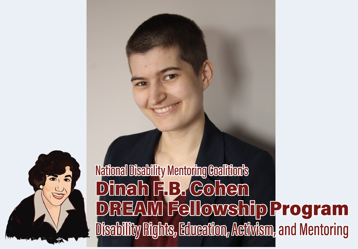 A fair-skinned androgynous person with a dark brown buzz cut and brown eyes smiles at the camera. They are standing in front of a light gray wall. They are wearing a dark red shirt and a navy blue blazer overtop.